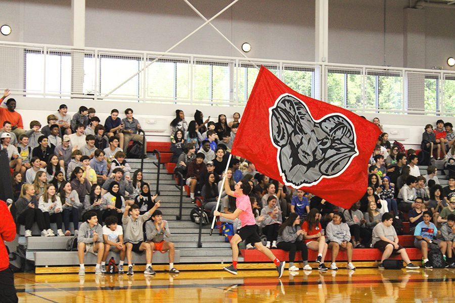 Image of student running with school flag during pep rally