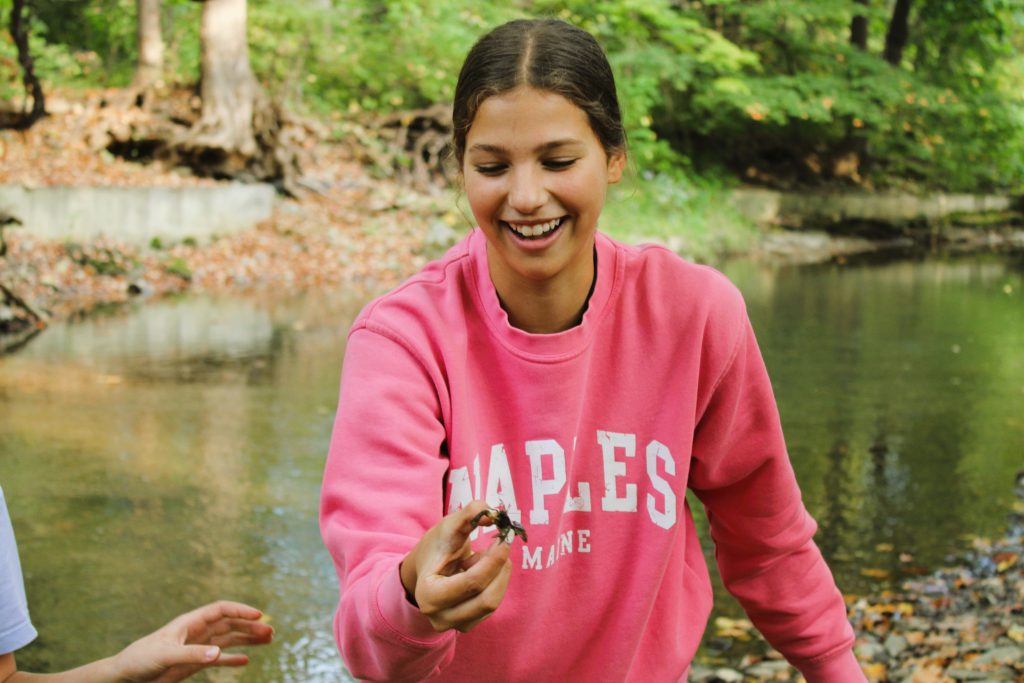 Image of student holding crayfish.