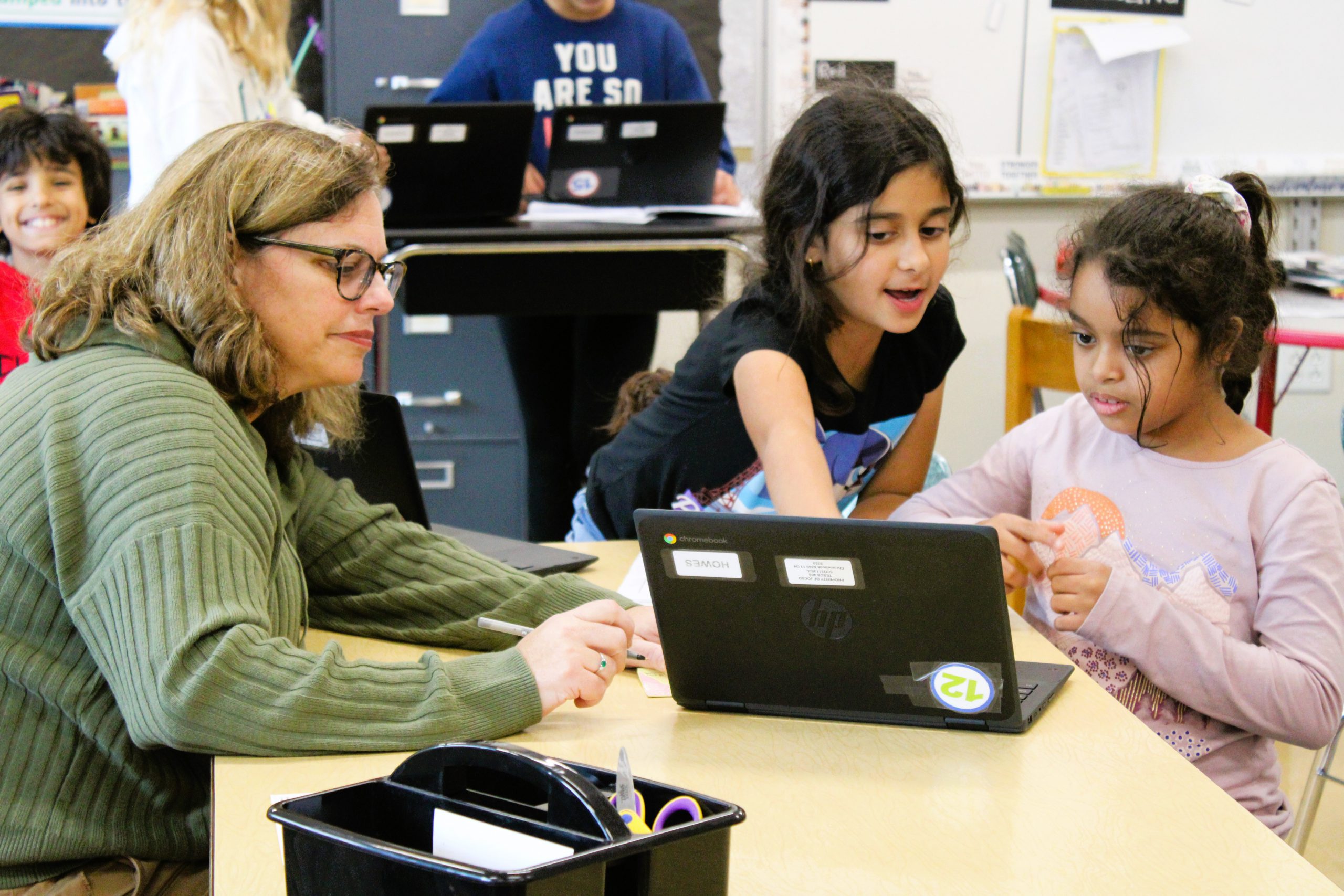 Image of teacher working with students.