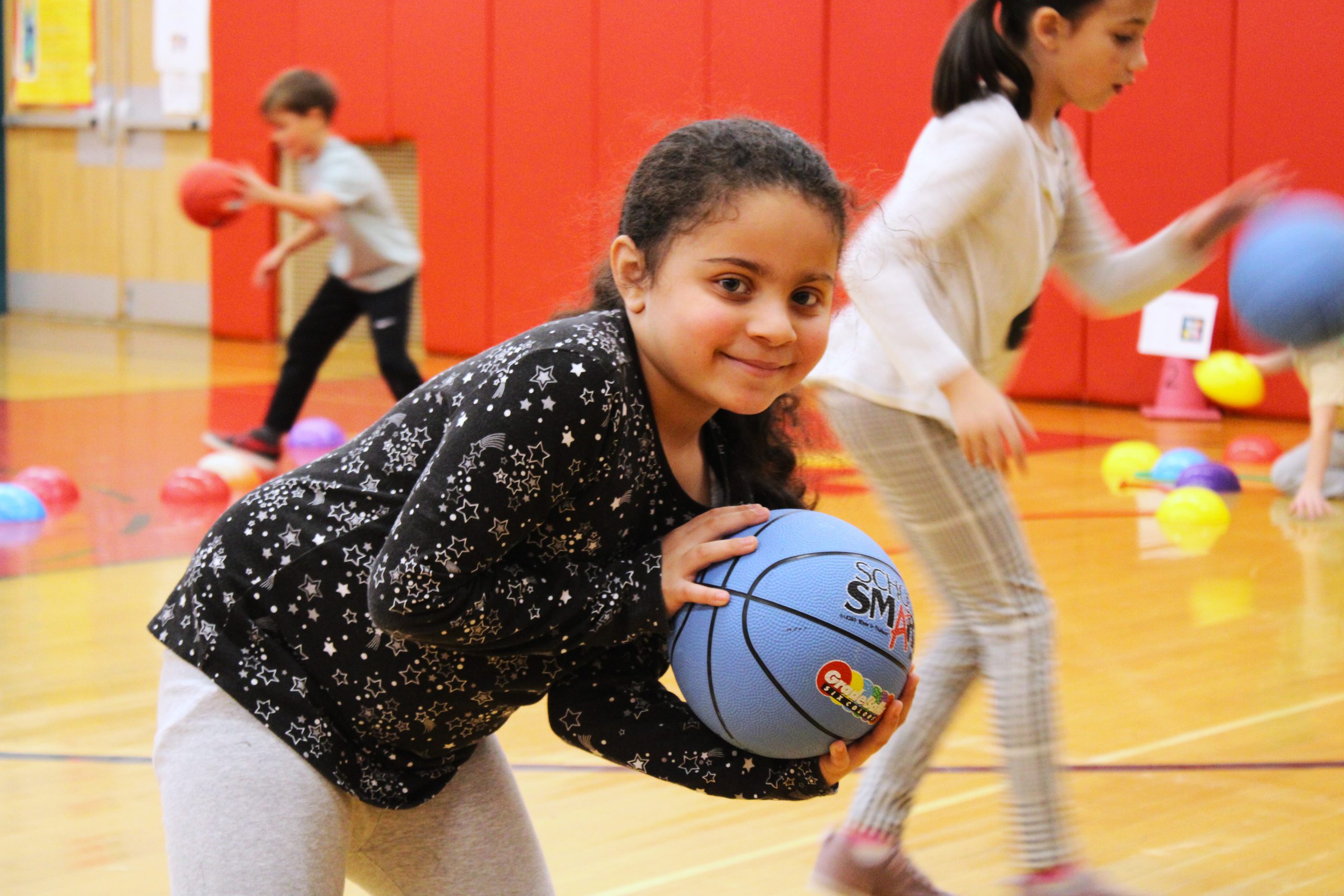 Image of student posing with basketball during gym class.