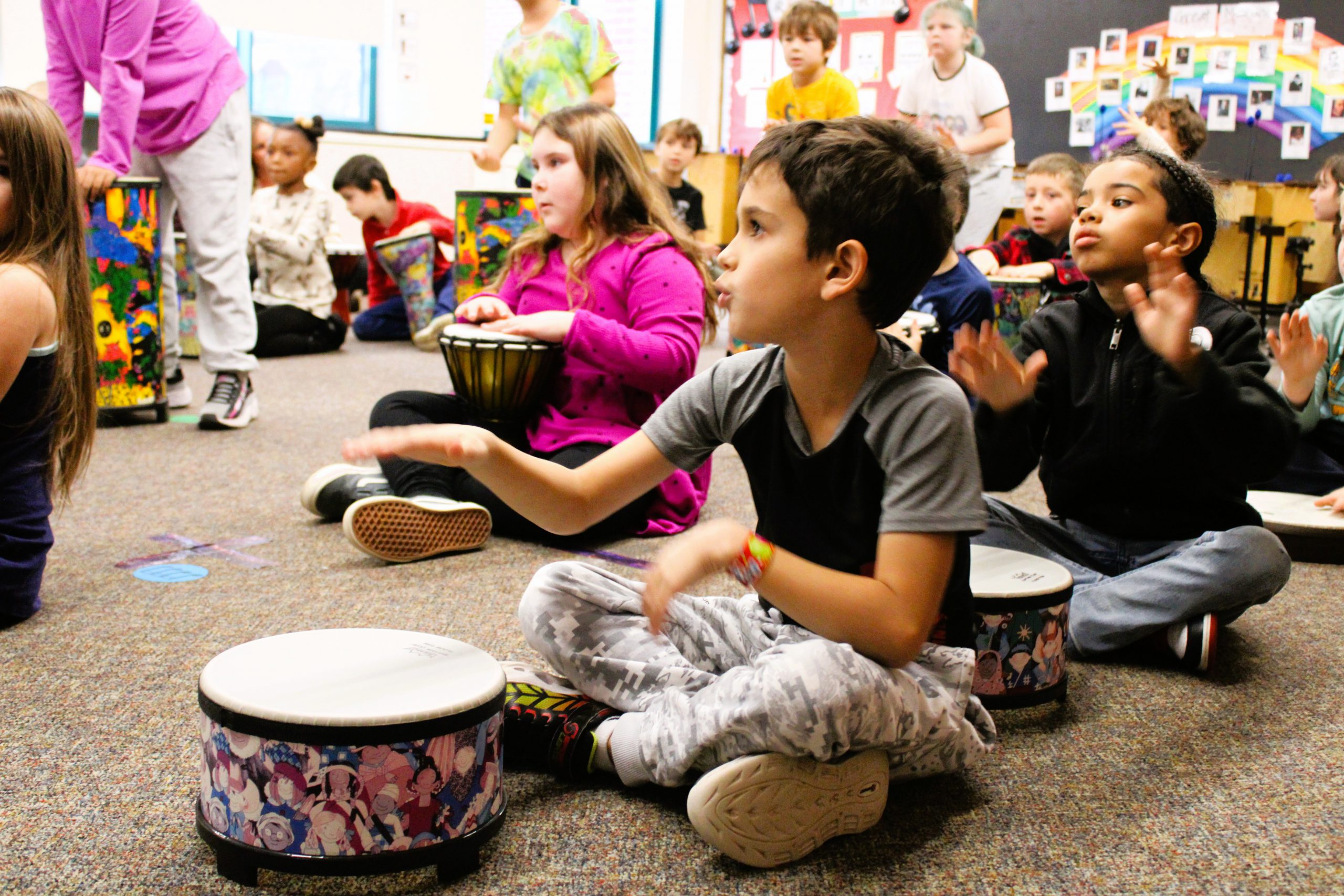 Image of student playing drum in music class.