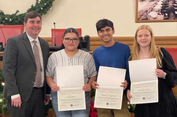 Image of J-D High School seniors Amanda Aitken, Karunmay Aggarwal, and Karla Wade posing with Senator John Mannion. 