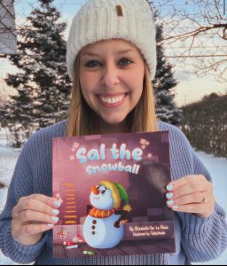 Image of Elizabeth De La Roca holding her book, "Sal the Snowball."