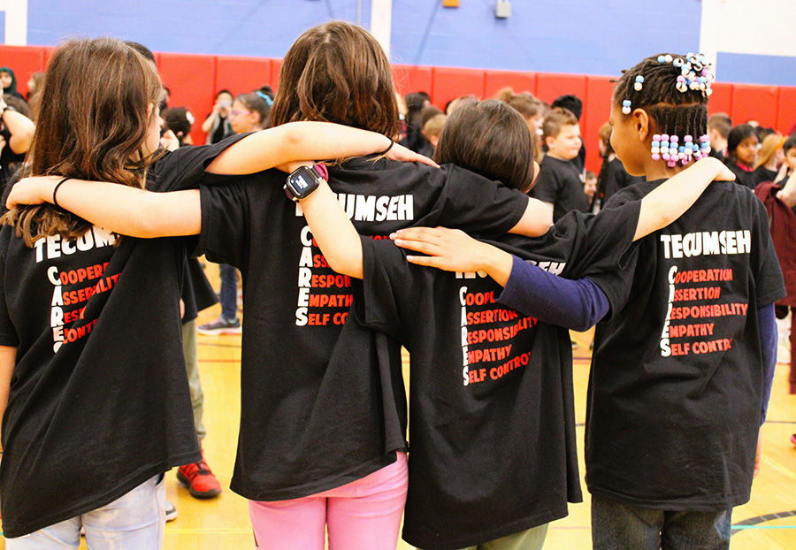 Image of students with arms around each other's shoulders wearing Tecumseh CARES shirts.