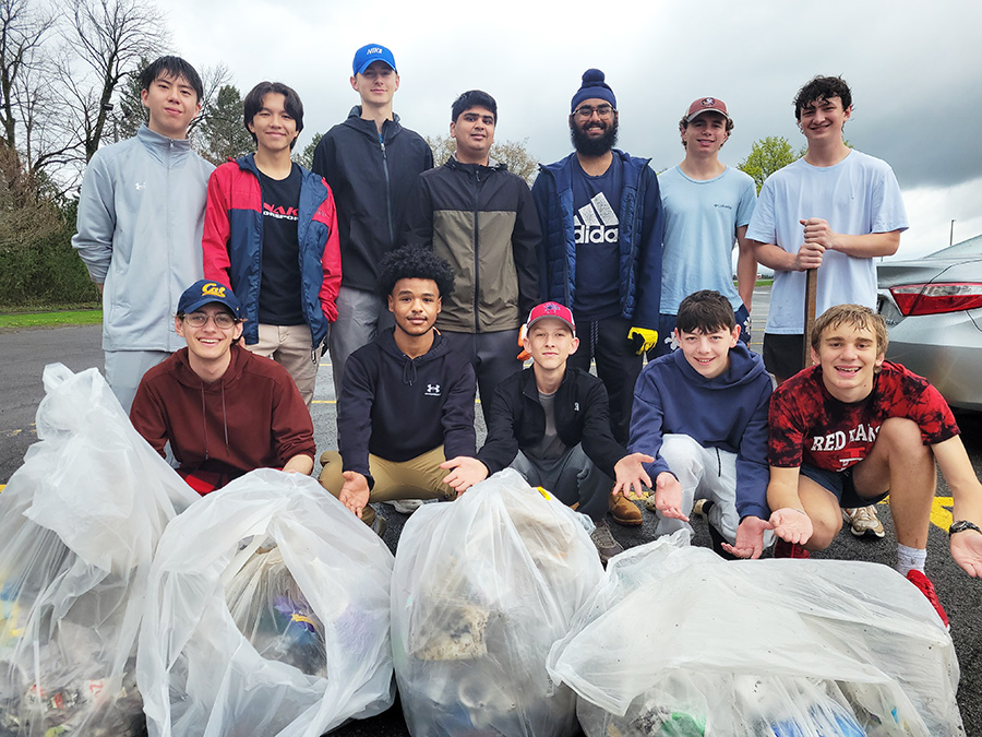 Varsity Tennis team poses with collected trash for pick up event.