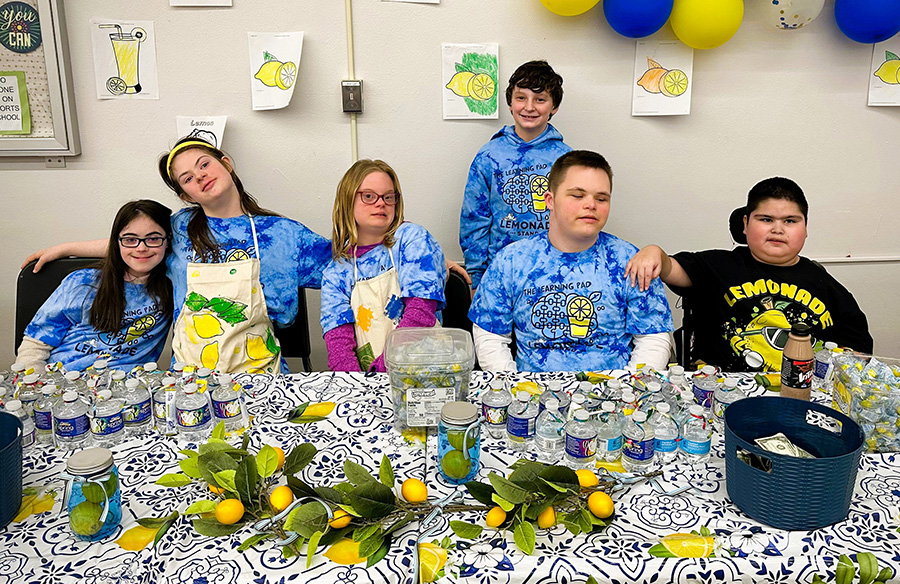Students sell lemonade with matching blue tie dye shirts.