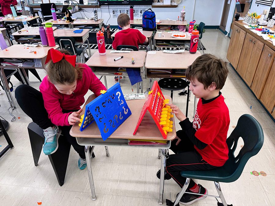 Two students play board game for Global Play Day.
