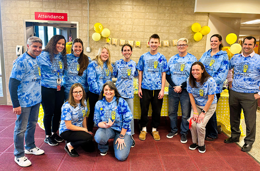 Students and staff pose for group photo during lemonade sale to raise autism awareness.