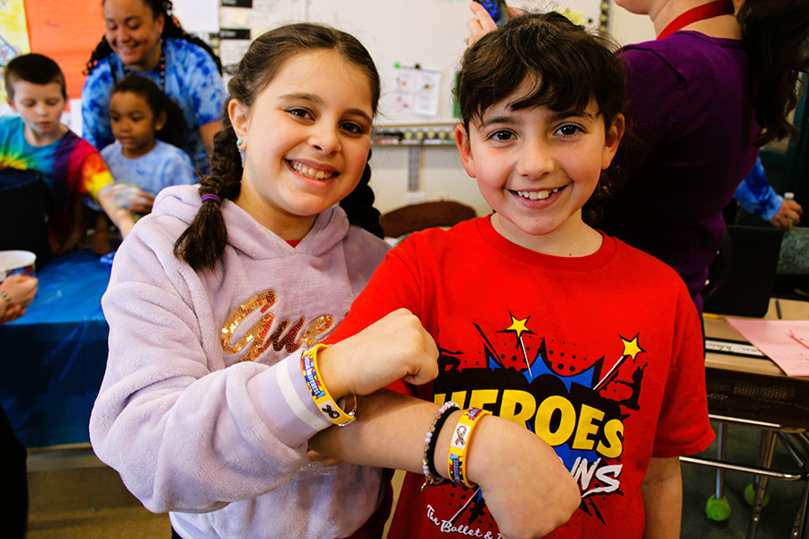 Two students show off Autism awareness bracelets.