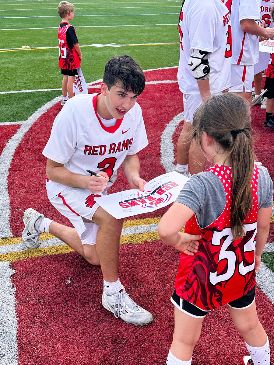 Lax Parker signs autograph for young fan.