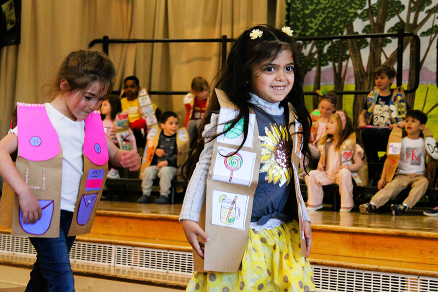 Tecumseh Kindergarten students walk in ABC fashion show wearing decorated letter vests.