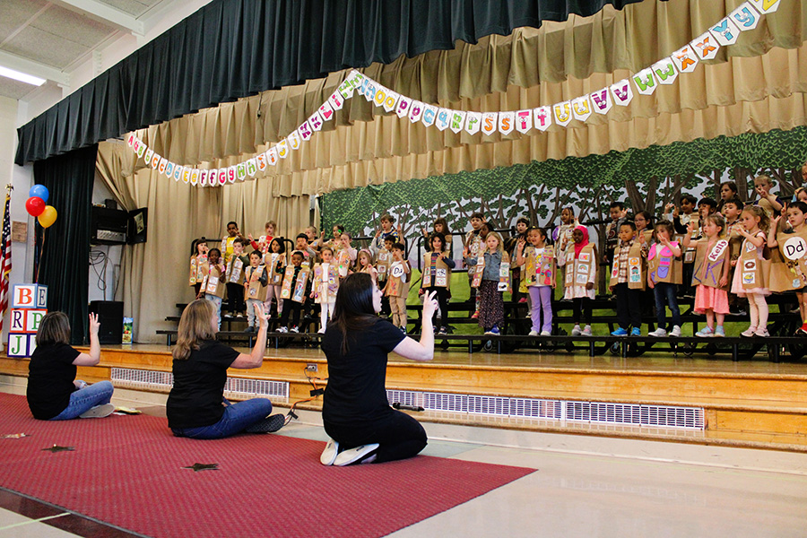 Tecumseh Kindergarten students perform song during ABC fashion show wearing decorated letter vests.