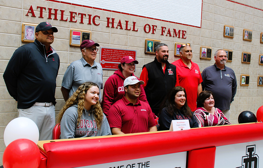 J-DHS senior Bryce Wheeler smiles with family and coaching staff at signing event.