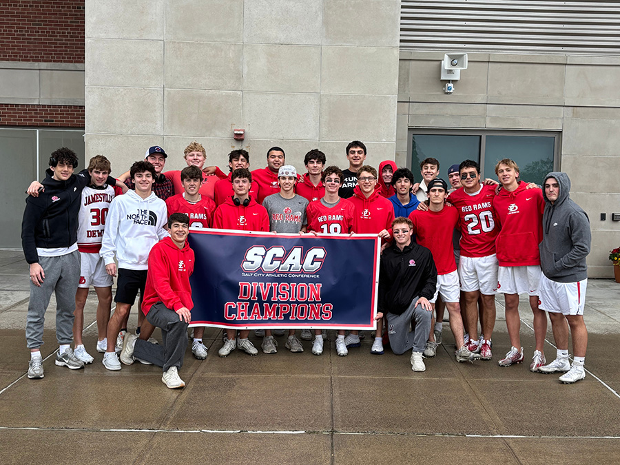 2025 boys lacrosse team pose with SCAC League Champs banner.