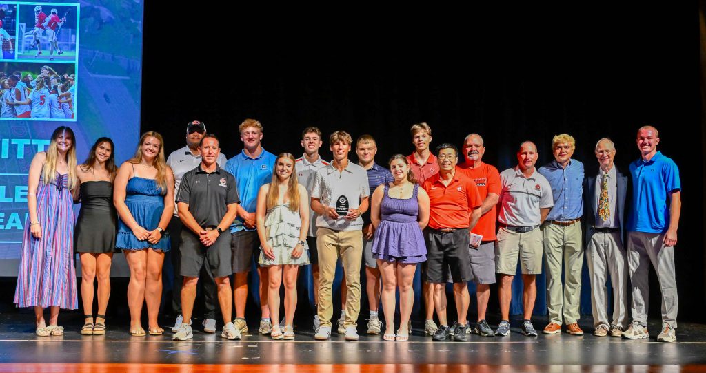 Jamesville-DeWitt student-athletes and coaching staff pose for group photo on stage at All-CNY sports awards.