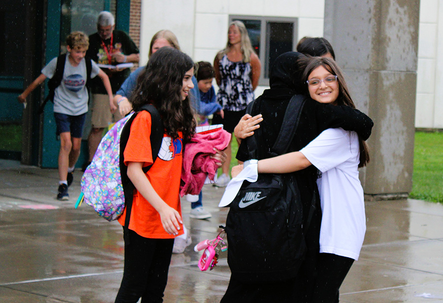 Middle students hug during last day of school dismissal.