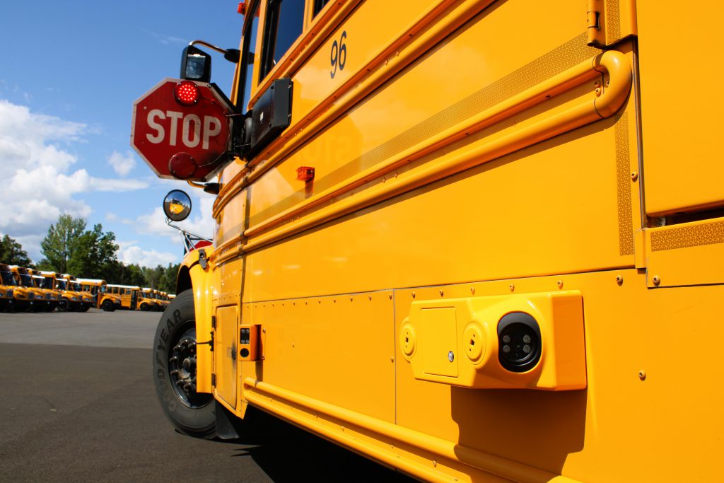 Side of school bus showing cameras angled towards and away from stop arm.