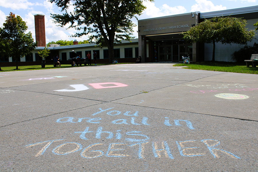 Close up of inspiration chalk message on sidewalk in front of high school.
