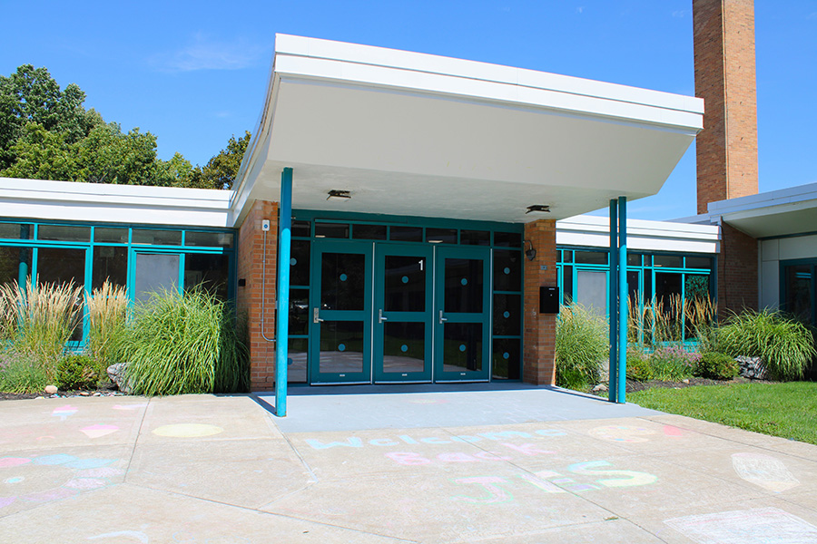 Exterior main entry of Jamesville Elementary School with welcome chalk message.