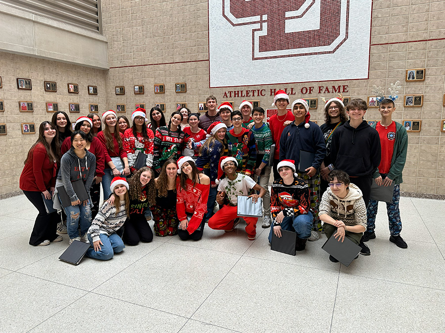 In Achord poses for group photo wearing holiday outfits after caroling.