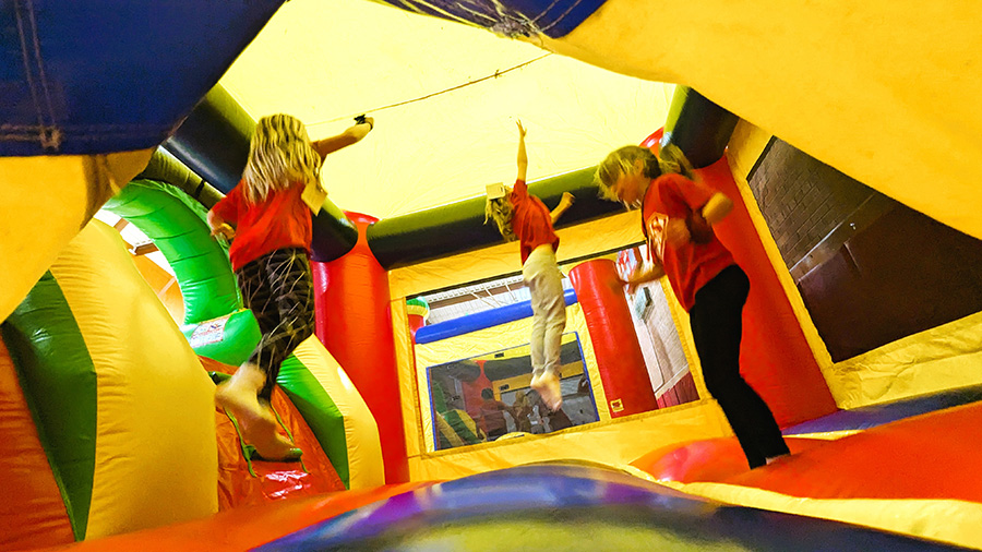 Three students jump inside jump house.