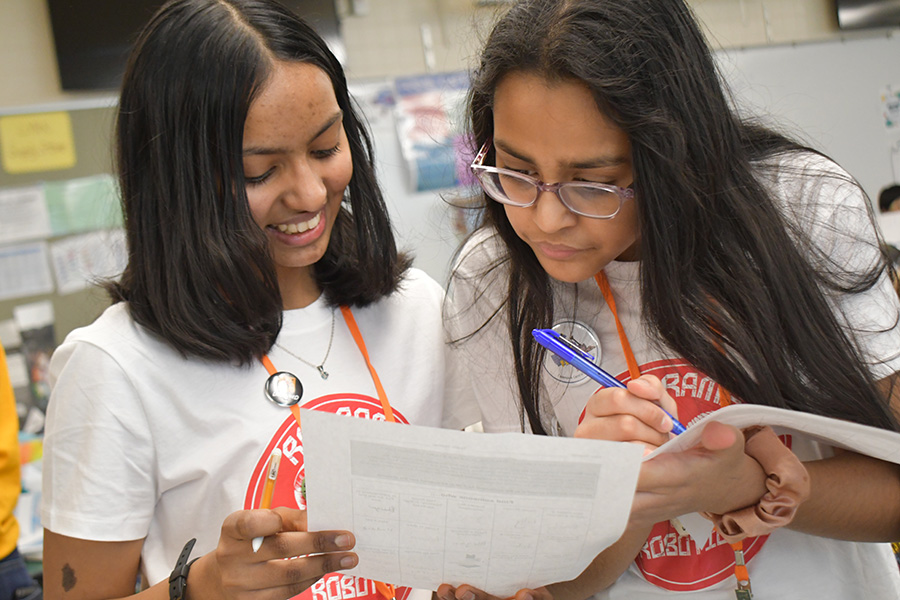 Two students look at paper.
