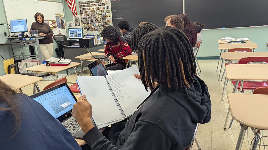 Students work on assignment in classroom desks.