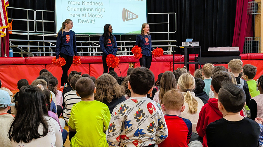 Students watch Syracuse University cheerleaders during assembly.