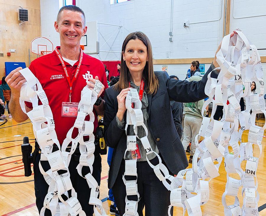 Superintendent Woodcock and SPO Schmitt hold up paper kindness chain.
