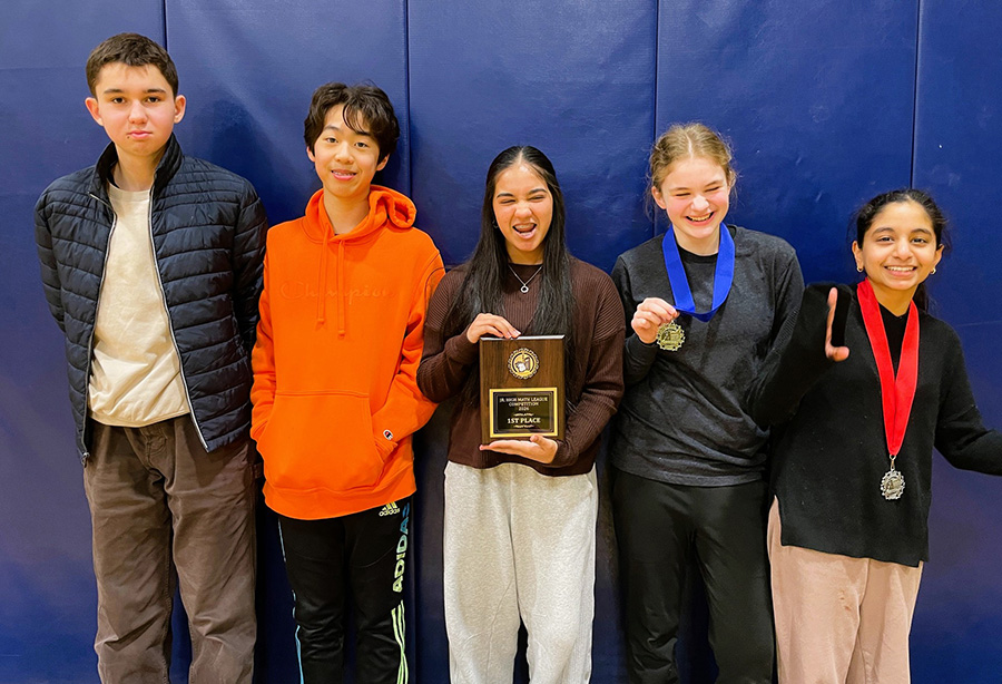 Five students pose with plaque trophy.