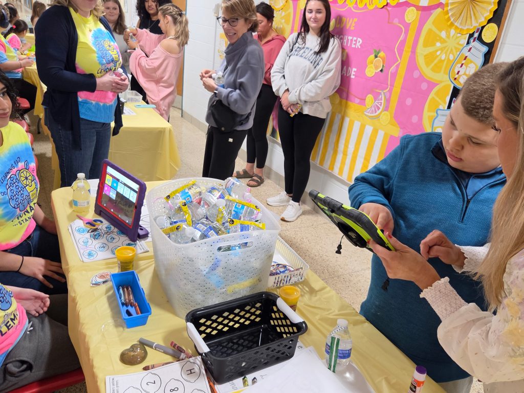 Student uses ipad with staff to sell lemonade.
