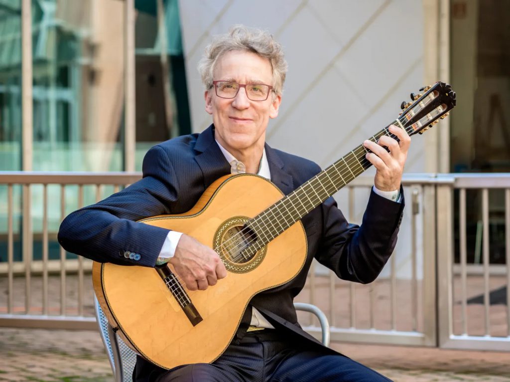 Eliot Fisk poses for photo with guitar.