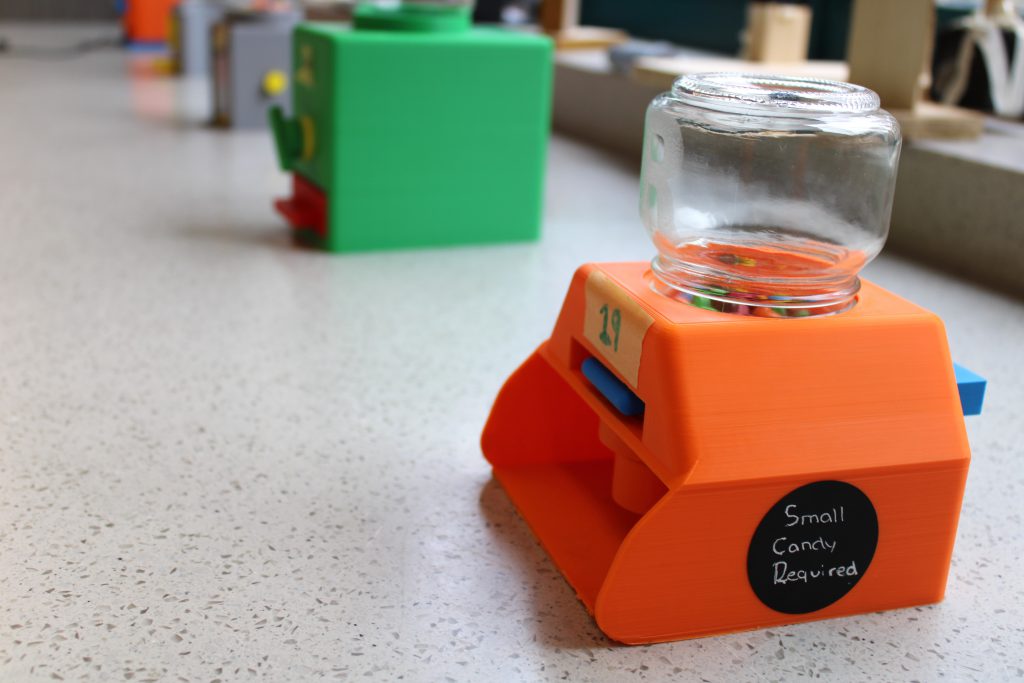 A close up of 3D printed candy dispensers on table.