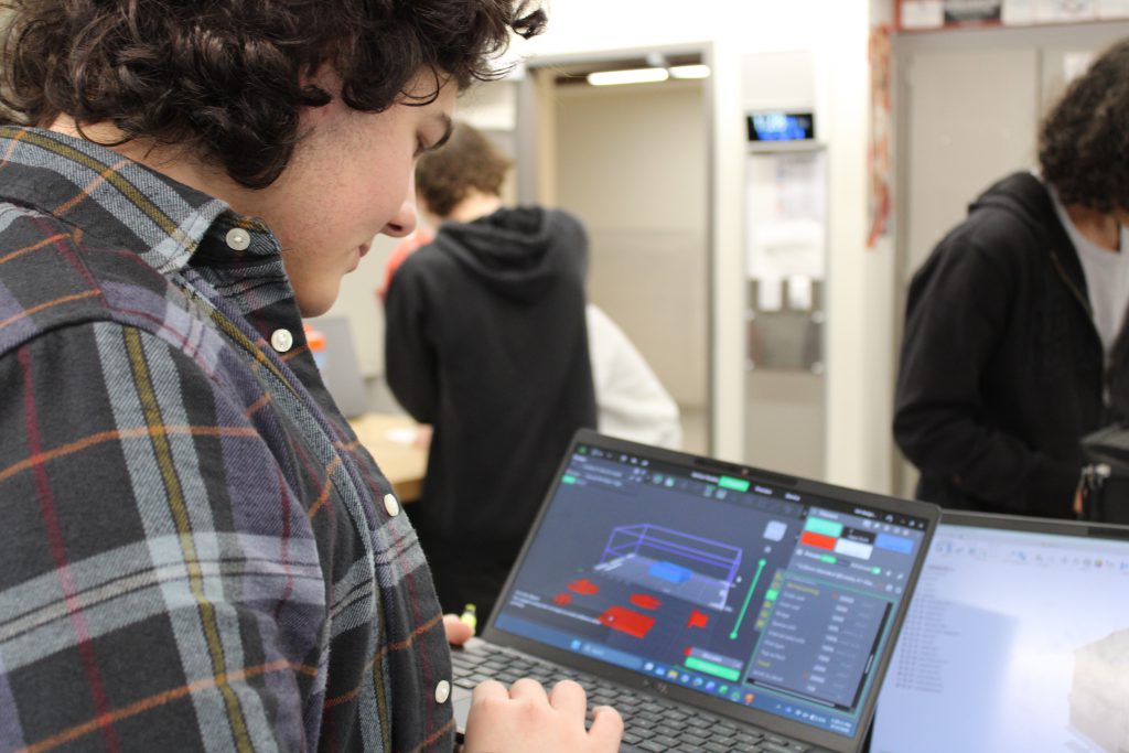 Student uses CAD software on laptop.