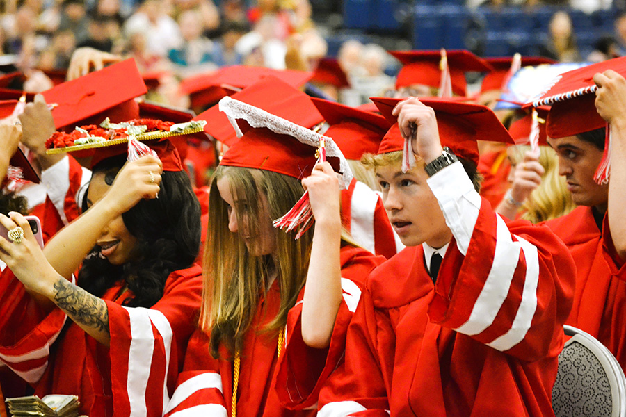 Graduates move tassels on caps.