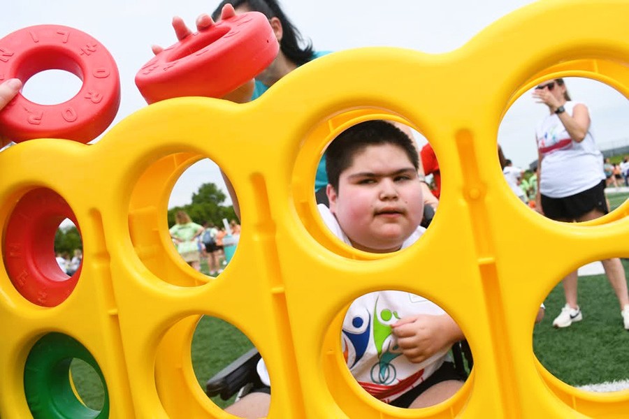 Student looks through hole of yard game.