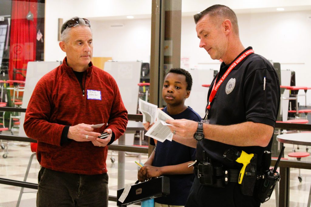 SPO checks paperwork of parent picking up student.