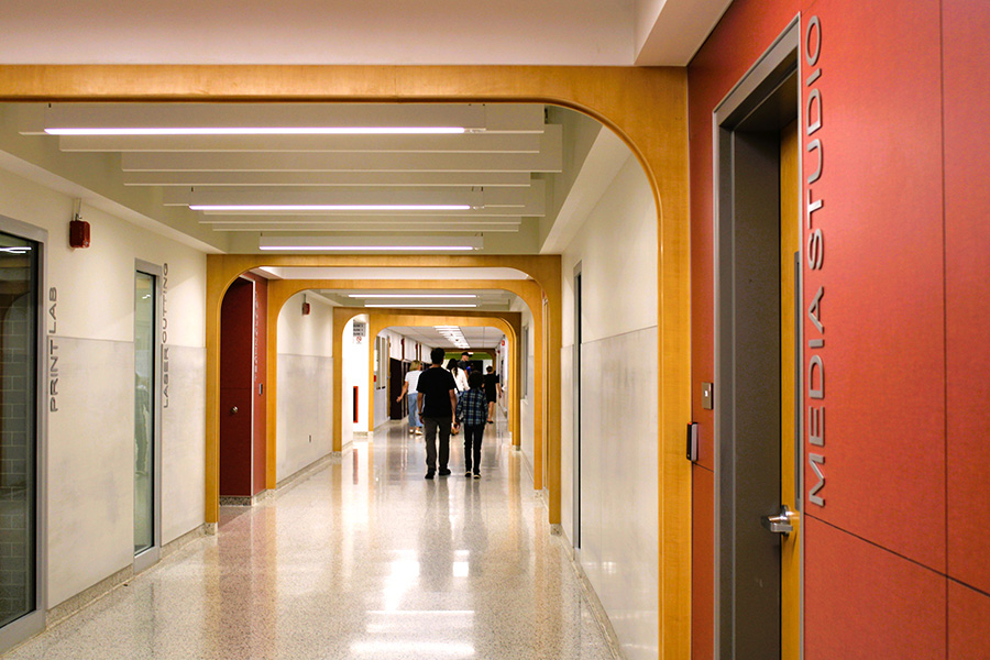 Families walk down middle school hallway.