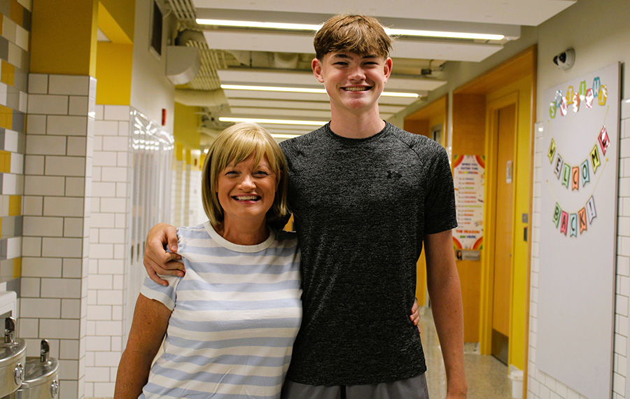 Mother and son pose for photo in hallway.
