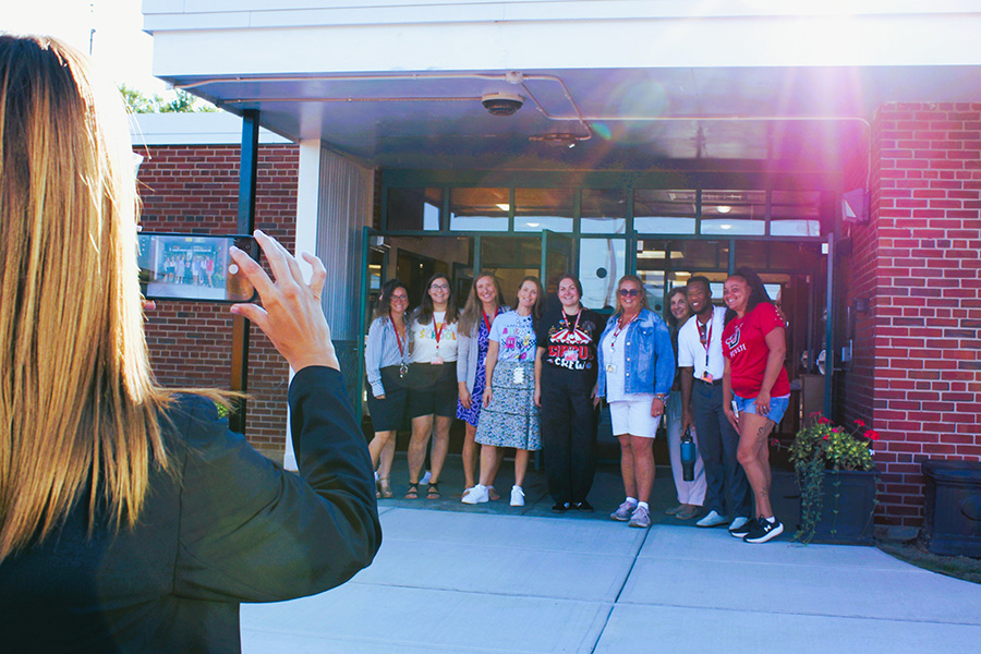 Staff pose for group photo outside of building.