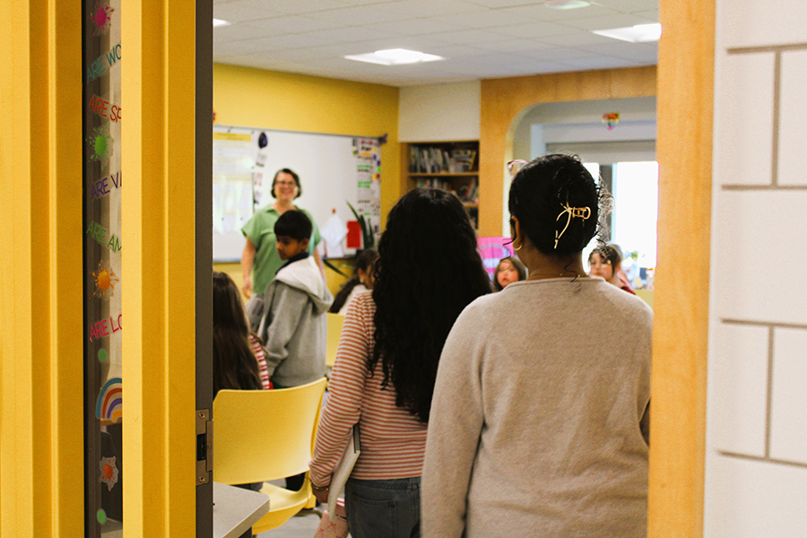 Students look at teacher in classroom.