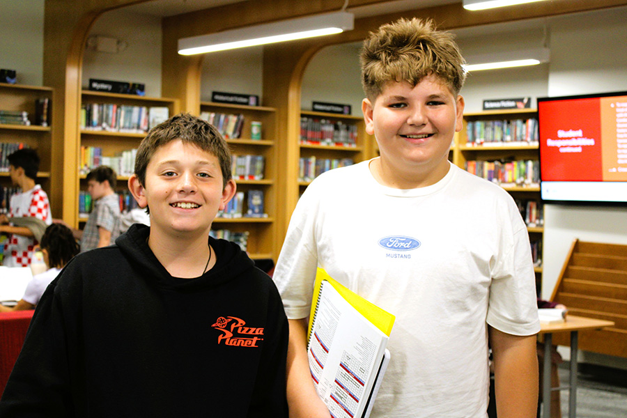 Two students smile in library.