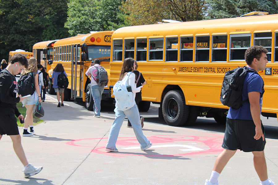 Students walk towards buses at dismissal.